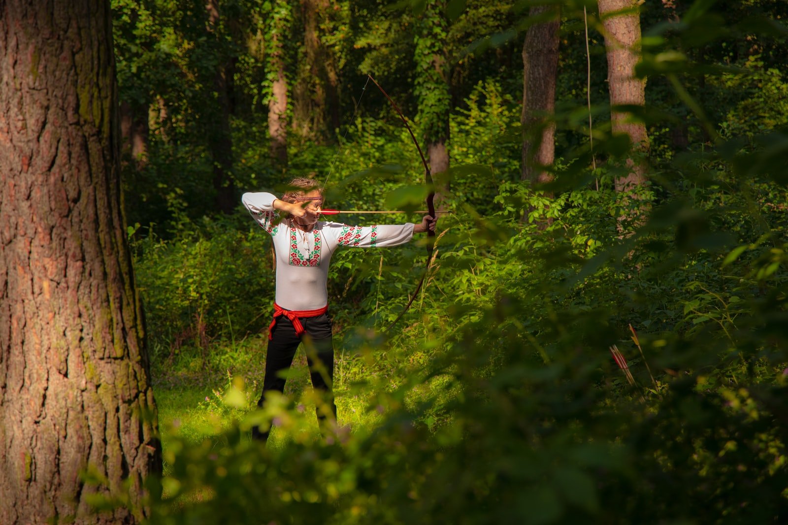 A Guide to Alignment in D&D 5e 1 woman in white long sleeve shirt and black pants holding bow